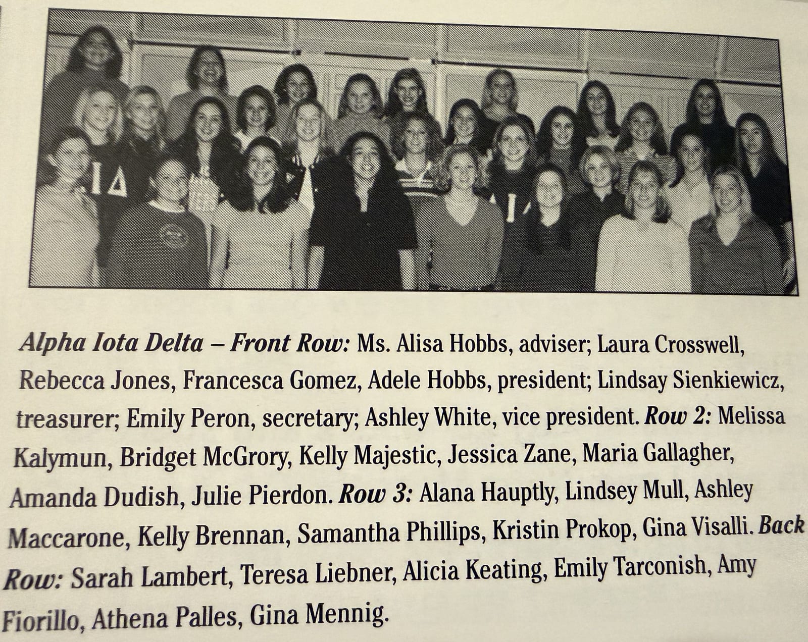 A black-and-white yearbook group photograph of about two dozen young women in several rows, above a printed caption listing their names.