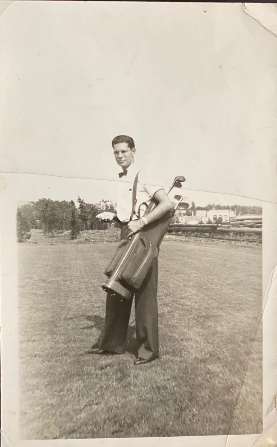 Peter S. Palles in the 1940s, standing on a fairway with a golf bag — family collection print.