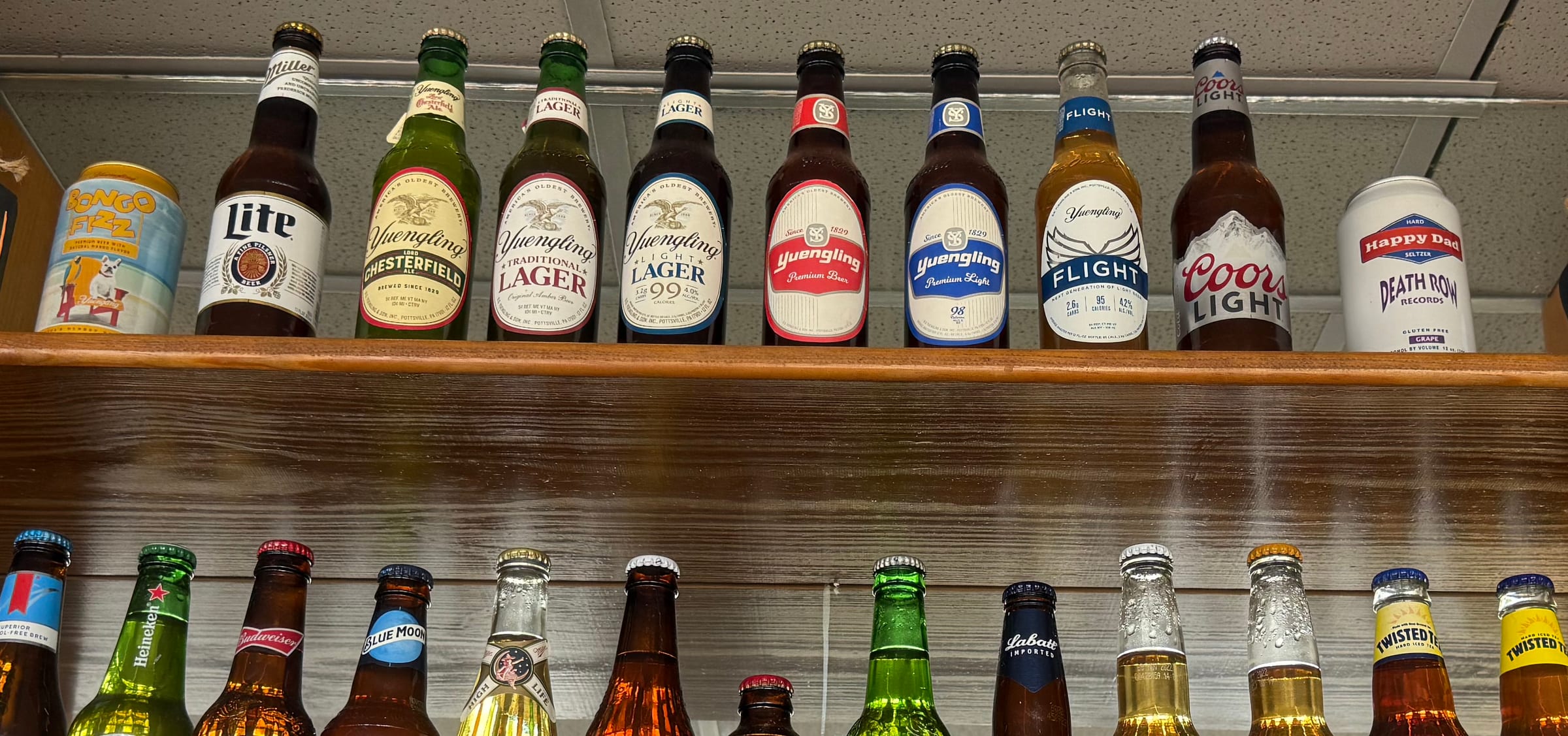 Bottled beers on the shelves at The Coney Island in Pottsville, PA — Yuengling, Coors Light, Heineken, Blue Moon, Corona, Twisted Tea.