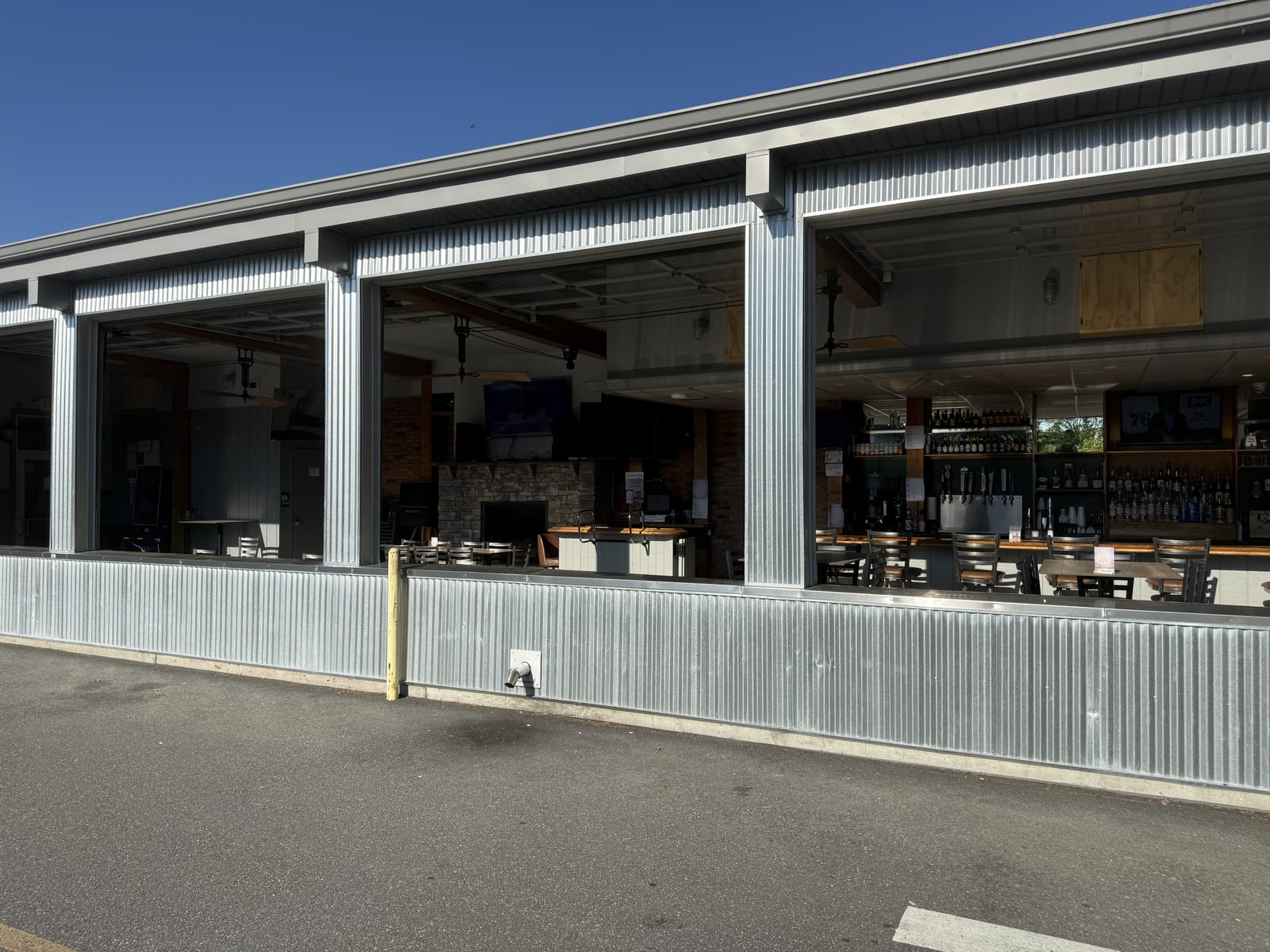 The four-season patio at The Coney Island with its roll-up glass garage doors open to warm weather.